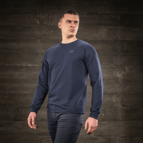 M-Tac Raglan Athlete sweatshirt in minimalist design with raglan sleeves, shown on a model against a rustic background.