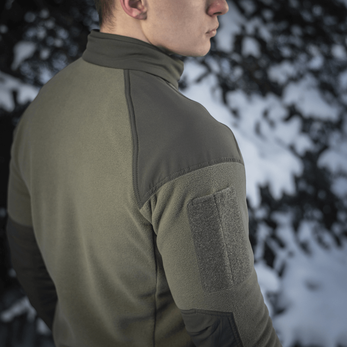 Bagside af M-Tac Combat Fleece Jakke i grøn, lavet af Himates fleece med vindtæt stof for komfort og holdbarhed.
