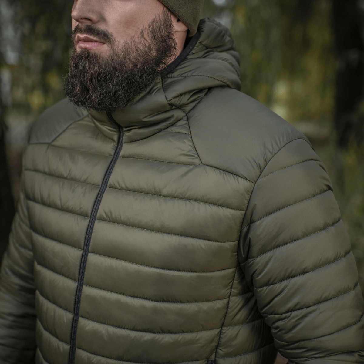 Person iført M-Tac Stalker Gen.III Jakke i naturen, ideel til overgangssæsonen med G-LOFT isolering og justerbar hætte, komfort til -15°C.