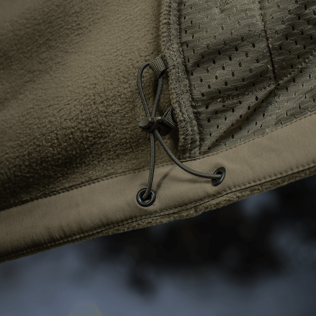 Detaljebillede af M-Tac Combat Fleece Polartec Jakke med snørelukning og meshindsats.