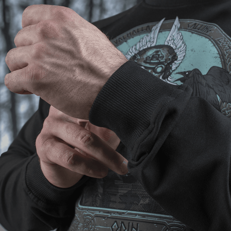 Mand justerer ærmet på M-Tac Raglan Odin Mystery med Odin-motiv, lavet i komfortabelt bomulds- og elastanmateriale, velegnet til hverdagsbrug.