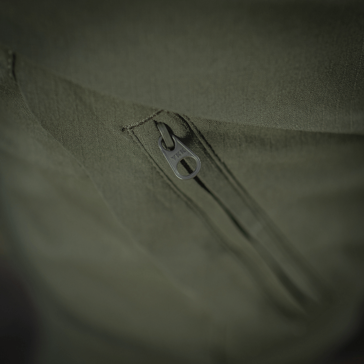 Nærbillede af lynlåsdetalje på M-Tac Bukser Aggressor Summer Flex Dame, viser kvalitets YKK-lukninger i grøn rip-stop nylonstof.