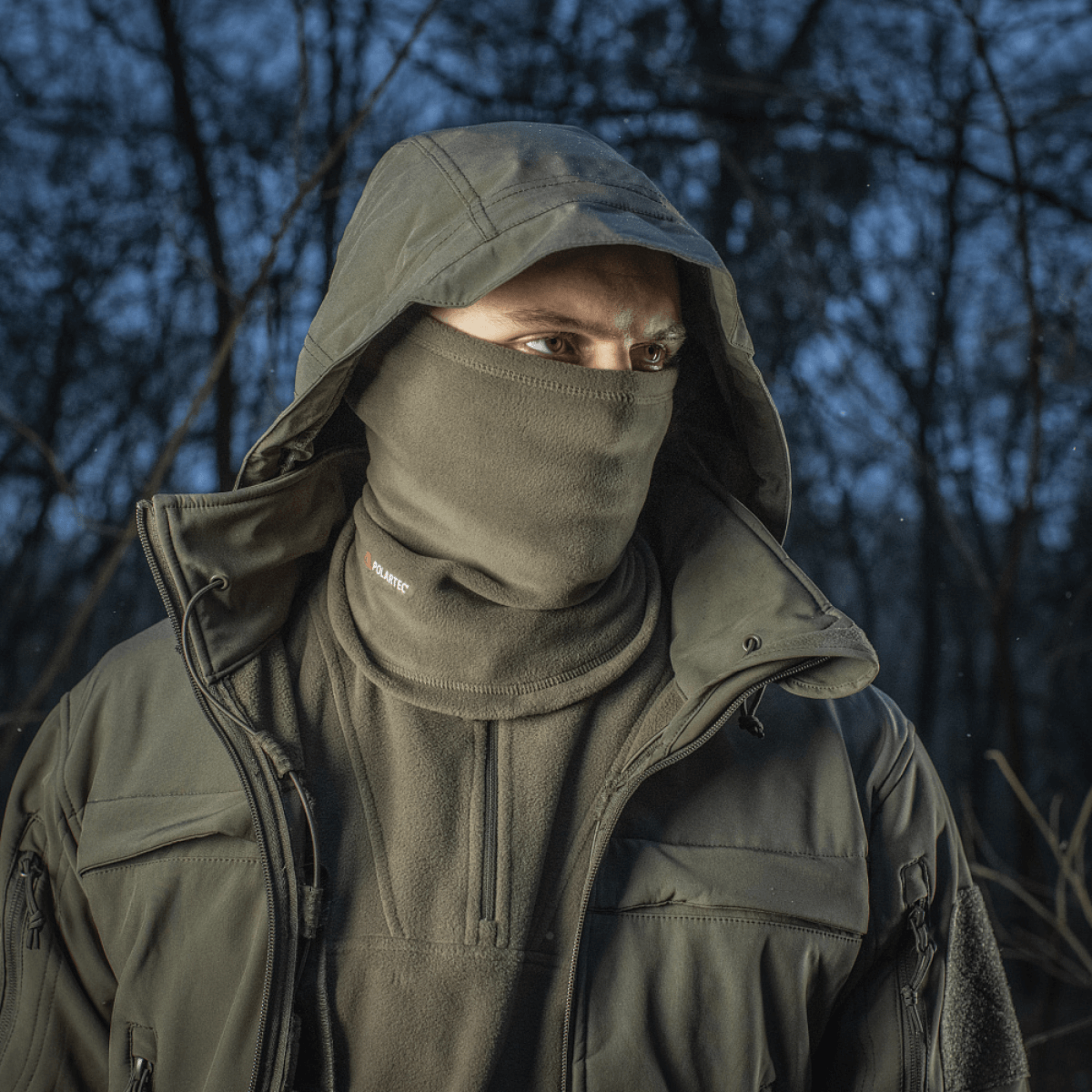 Mand iført M-Tac Tube Scarf Polartec halstørklæde i skov, beskytter mod vejret med Polartec Micro Series fleece, outdoor stil