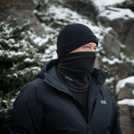 Mand iført M-Tac Tube Scarf Polartec til beskyttelse mod kulde og vind, ideel til udendørsaktiviteter i vintervejr.