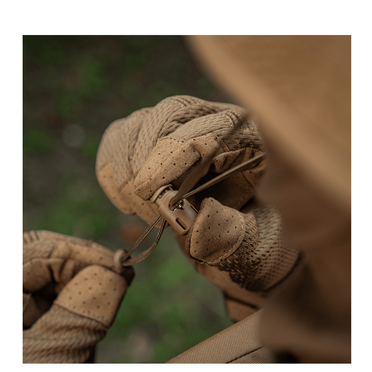 Close-up af hænder iført brune, robuste handsker, der tænder en brun snor på en M-Tac Panamahat Gen. II Summer Flex.