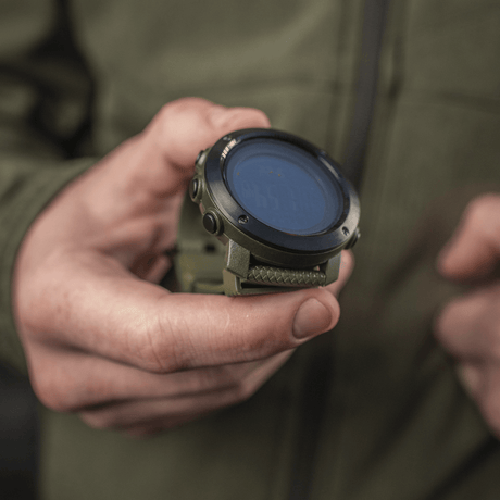 M‑Tac Multifunctional Tactical Watch held in hand, ideal for outdoor activities and military use, showing robust design and advanced features