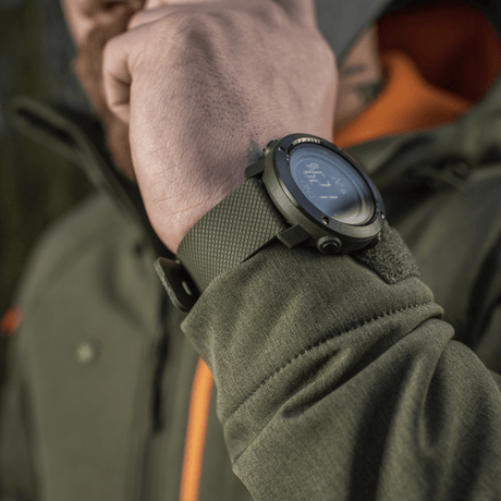 M‑Tac Multifunctional Tactical Watch on a man's wrist in an outdoor setting, ideal for outdoor activities with advanced features and durability
