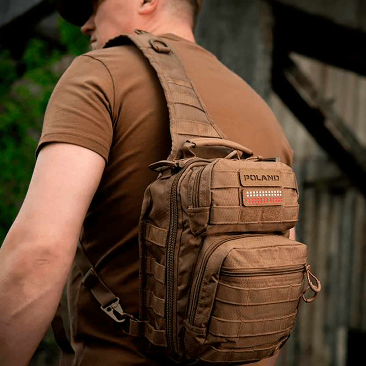 Mand med rygsæk udstyret med M‑Tac Patch Poland End-to-End 25x80 i holdbart Cordura materiale, fastgjort med velcro.