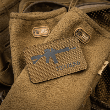 M-Tac AR-15 223/5,56 Laser Cut Patch attached to brown tactical blanket with M-Tac logos, designed for outdoor and military use.