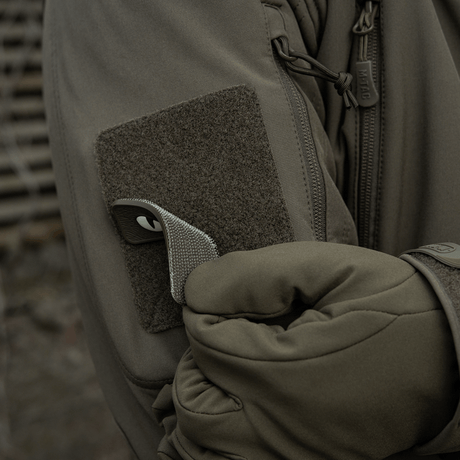 M-Tac Cat Eyes 3D PVC Patch attached to jacket sleeve with Velcro, ideal for outdoor activities and military use, reflective design.