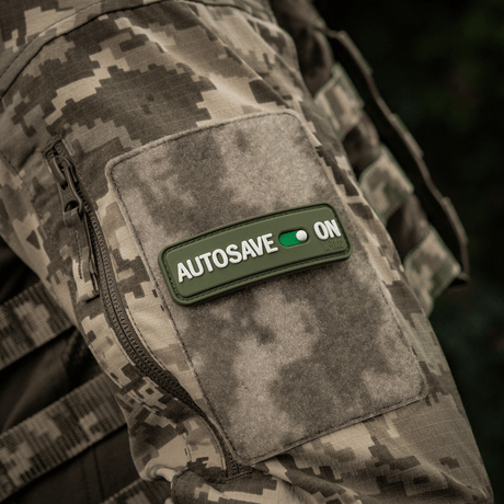 M-Tac Patch Autosave PVC on camouflage jacket, 3D morale patch in full color, suitable for clothing, backpack or tactical gear.