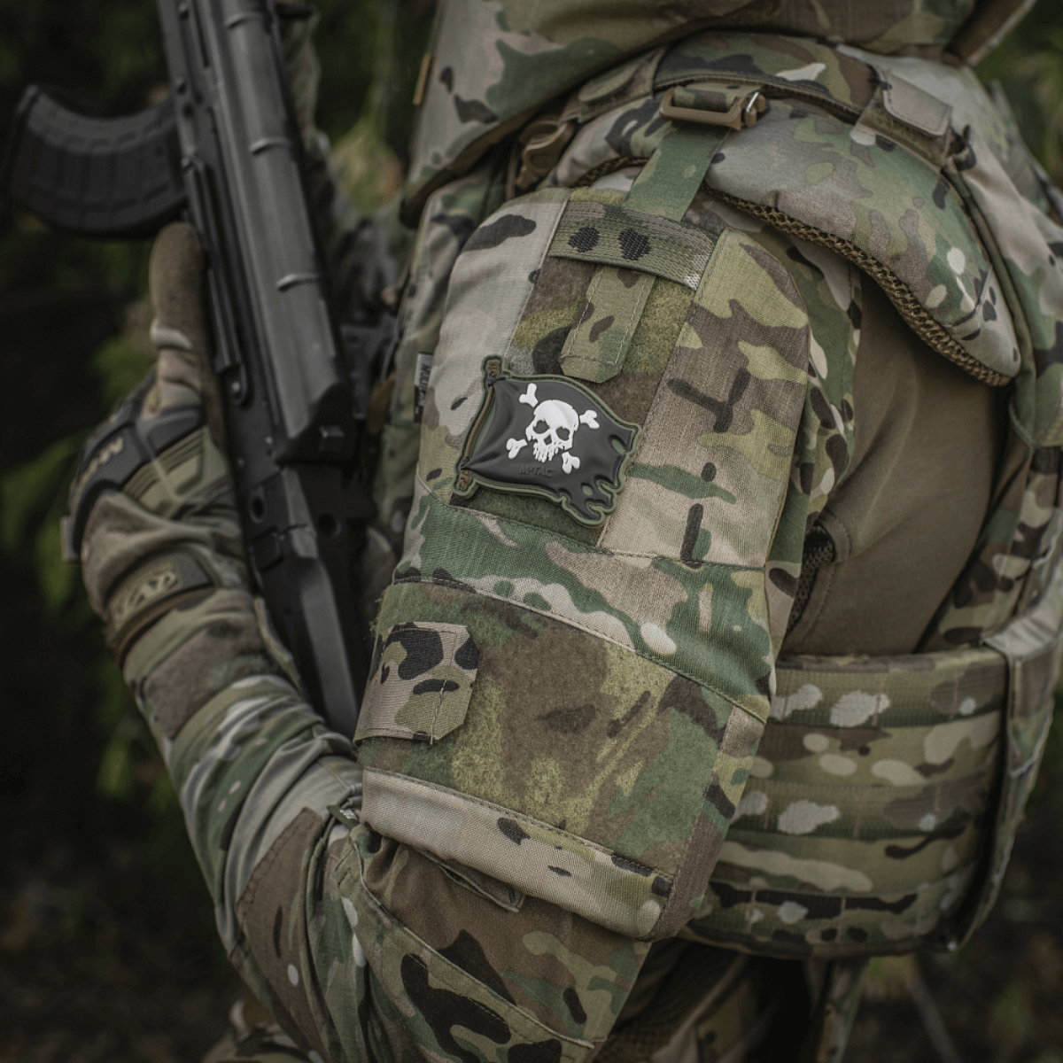 Soldat iført uniform med M-Tac Patch Jolly Roger PVC på armen, fuldfarvet 3D morale patch med velcro, symboliserer eventyrlyst og beslutsomhed.