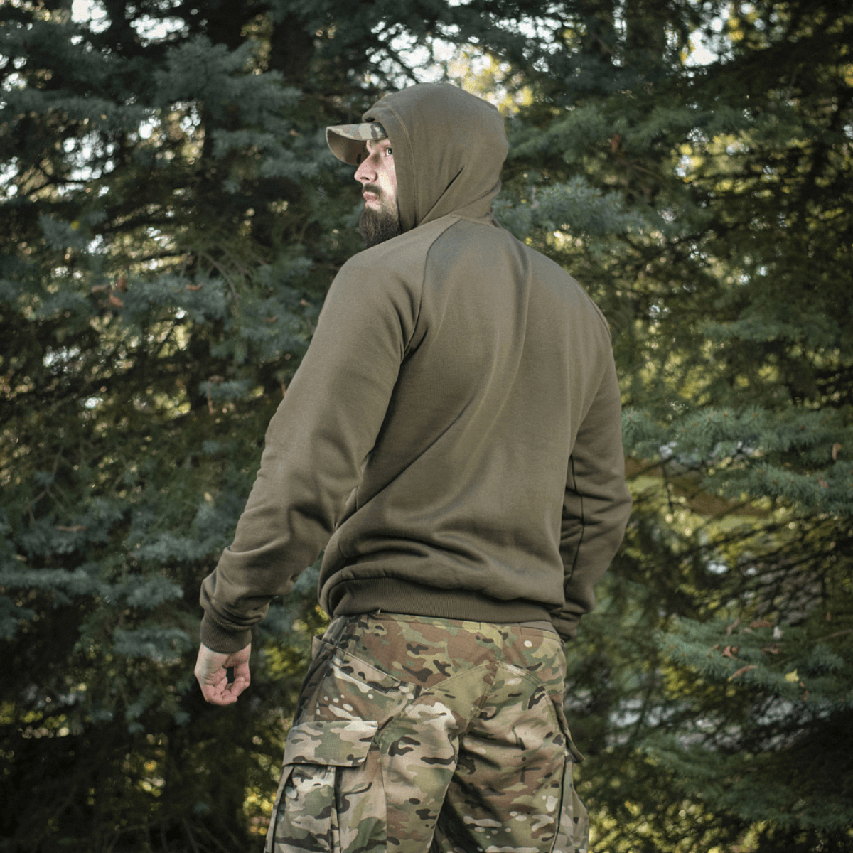 M-Tac Cotton Raglan Hard Hoodie i skovmiljø med stilfuldt design, kængurulomme og raglanærmer, perfekt til udendørs brug.