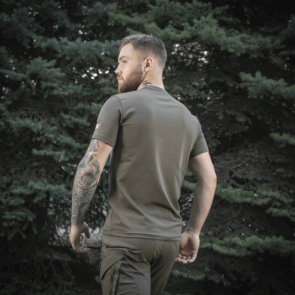 Mand iført M-Tac Sniper T-shirt i skovmiljø, bagfra, viser pasform og tætsiddende design