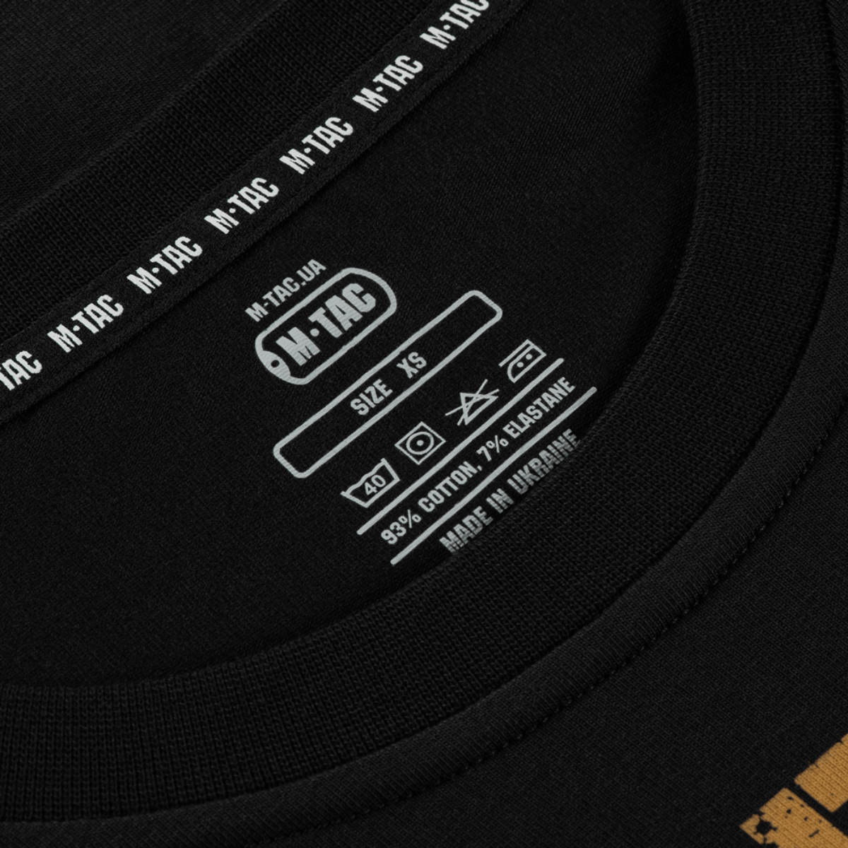 Nærbillede af M-Tac T-Shirt etiket, viser størrelse XS, 93% bomuld og 7% elastan, lavet i Ukraine.