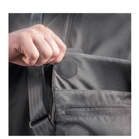 Hand opening a pocket on M-Tac Konvert Taske Elite made of durable Cordura material with magnetic flap opening.