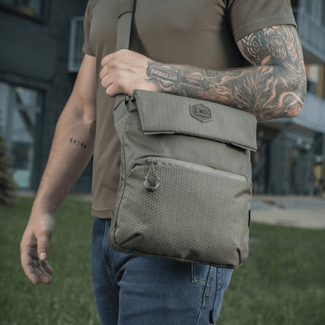 M-Tac Konvert Taske Elite worn by a person outdoors, made of durable Cordura 500D and Cordura Hex 1000D, with adjustable shoulder strap.