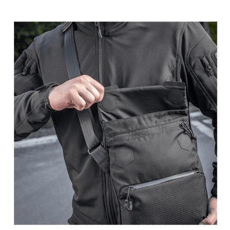 Man with M-Tac Konvert Taske Elite in Cordura 500D, showing the magnetic flap for quick access; the bag has an adjustable shoulder strap for comfort.