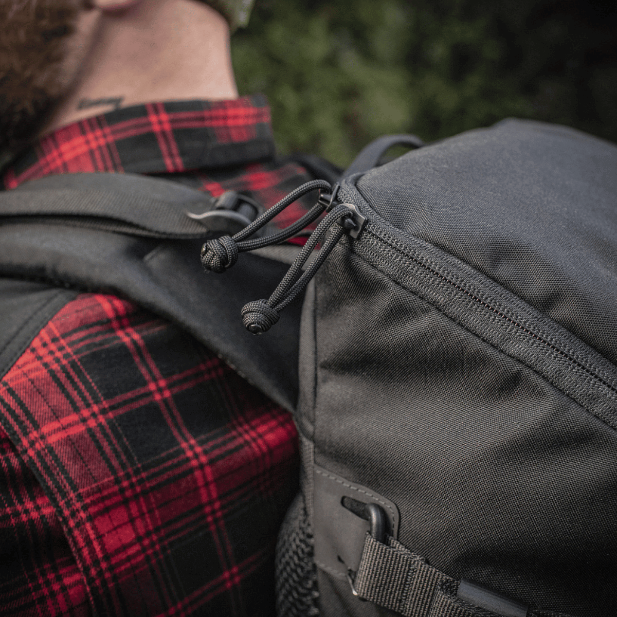 M-Tac Rygsæk Gen. II Elite – Small med lynlås og stropper set i brug mod en skovbaggrund.