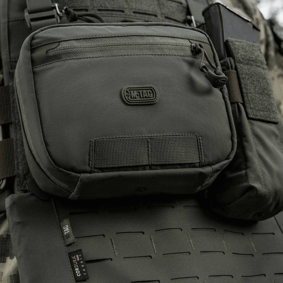M-Tac organizer pouch Elite fastgjort til taktiske vest via M.O.L.L.E.-systemet, ideel til bæring af nødudstyr og EDC-sæt. Holdbar og praktisk.