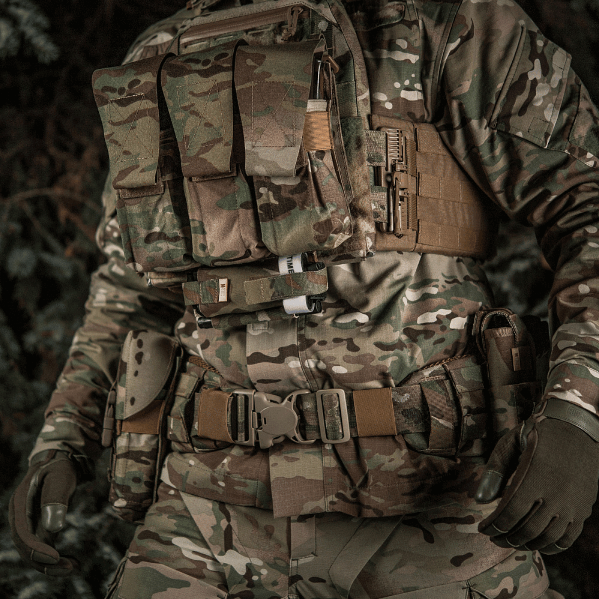 Soldat i camouflageudstyr med M-Tac Elastisk Tourniquet Holder Gen. III i Cordura 500D til C-A-T tourniquet, robust og slidstærk.
