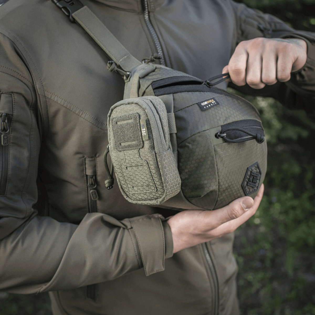 Mand bærer M-Tac PC Utility Taske Elite Hex monteret på skudsikker vest, lavet af Cordura HEX for stil og holdbarhed.