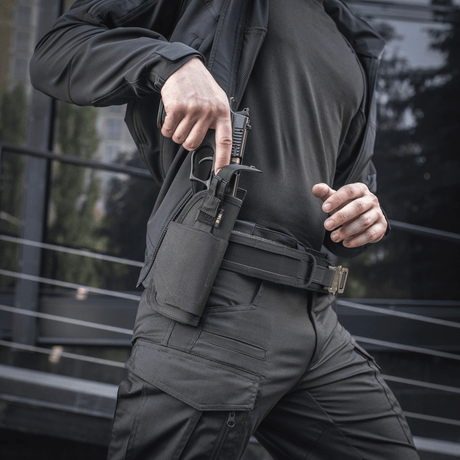 Person wearing M-Tac Universal Tactical Holster Elite Right, drawing a pistol from an adjustable holster with Laser Cut technology.