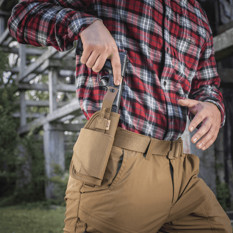 M-Tac Universal Tactical Holster Elite Right with adjustable strap and MOLLE interface for belt, shown outdoors with pistol.