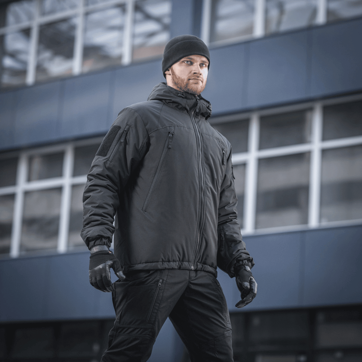 Mand iført M-Tac Alpha Gen.III Pro Vinterjakke i bymiljø, optimal til ekstreme forhold med komfort og vandafvisende materiale.