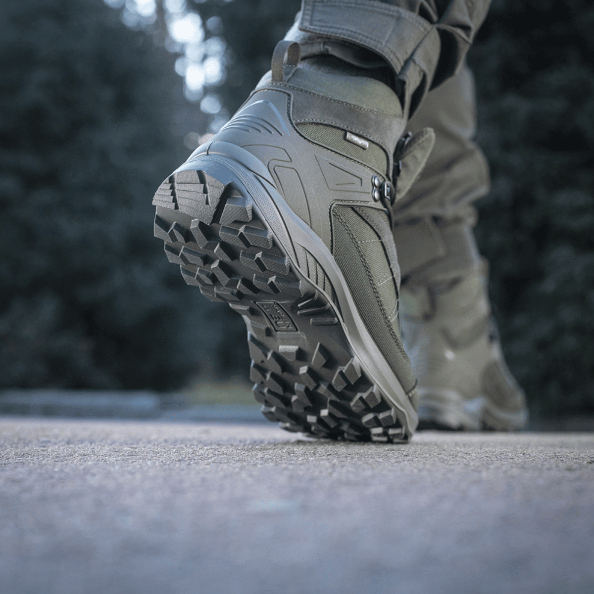 Nærbillede af M-Tac Taktiske Sæsonstøvler trækkende i udendørs terræn med synlig slidstærk sål og ruskind-overdel.