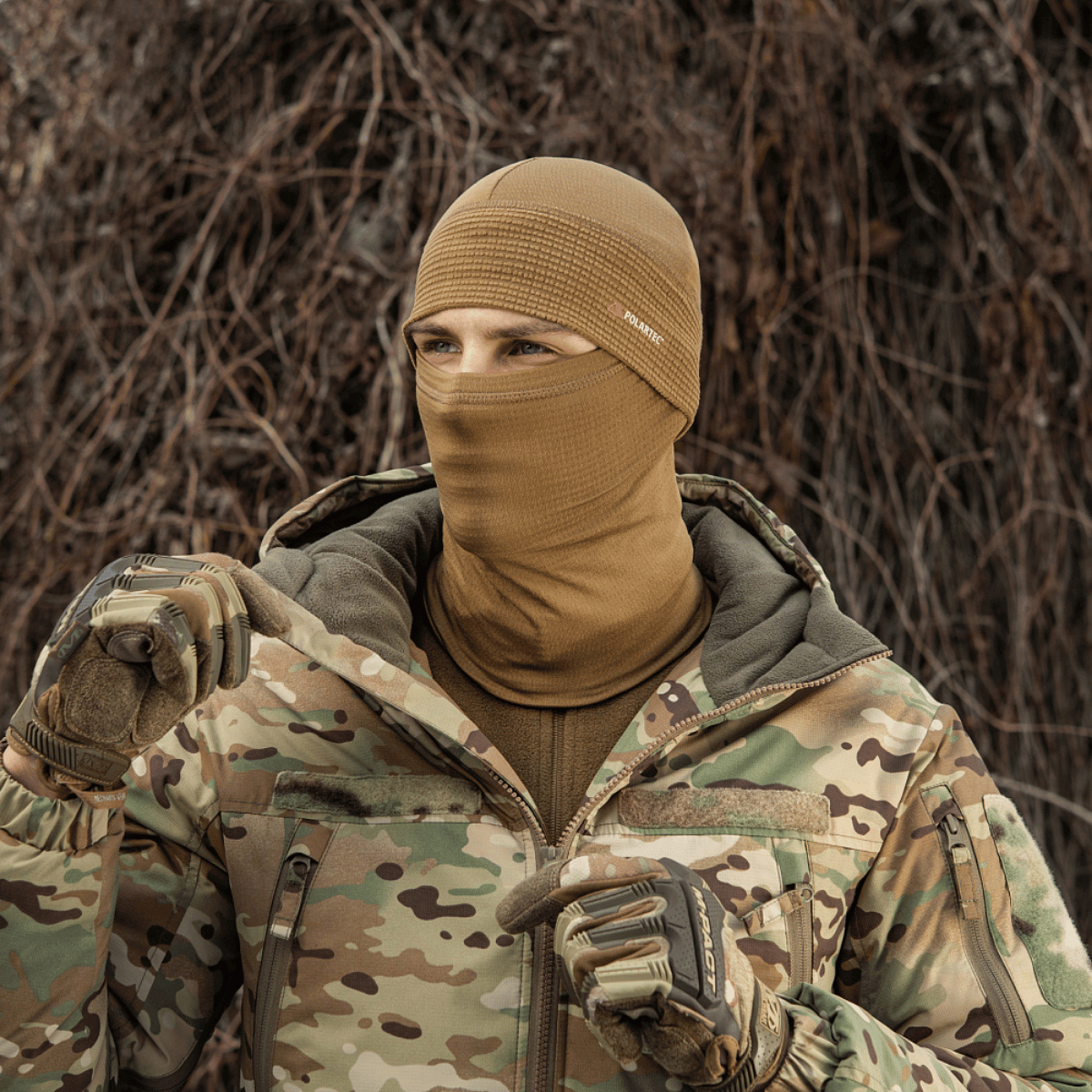 Person iført M-Tac Tube Scarf Polartec Power Grid i camouflage jakke