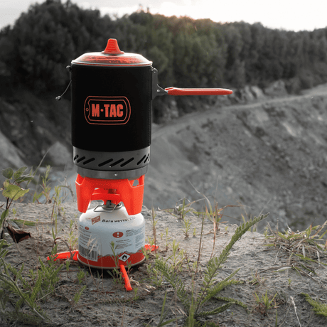 M-Tac Gas Burner with Kettle in use on a rock, ideal for camping and hiking — compact, energy-efficient cooking system