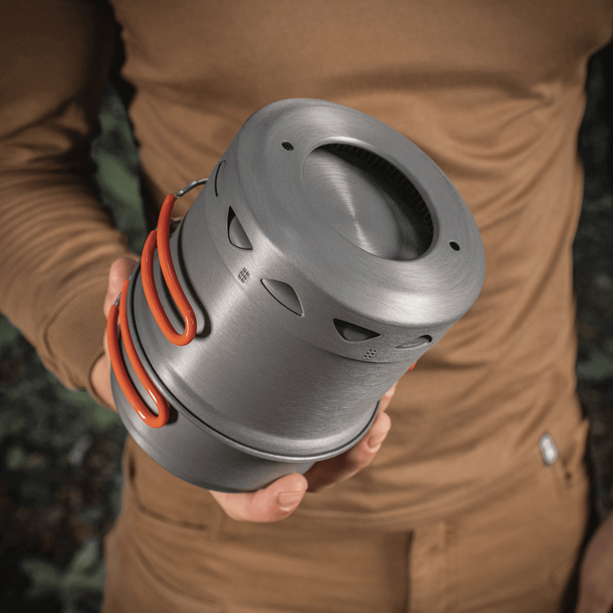 Person der holder et M-Tac Individuelt Kogesæt til Brænder i anodiseret aluminium, velegnet til camping og friluftsliv.