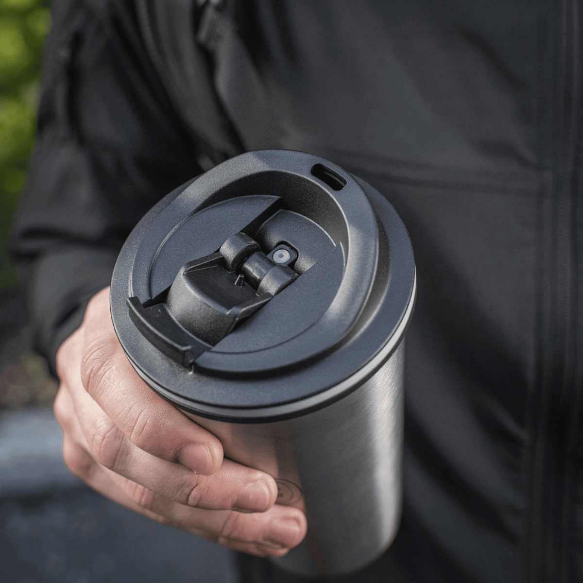 Person holder M-Tac Termokop 450 ml med ventil, designet til at holde drikken varm eller kold, med en praktisk tud og rustfrit stål konstruktion.