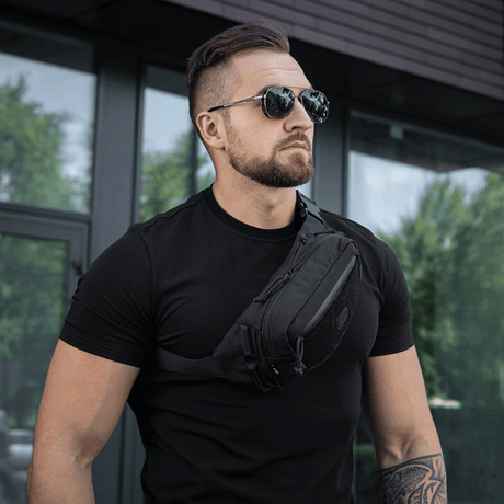 Man wearing M-Tac Waist Bag Gen.II in black, designed with stylish functionality, worn around the shoulder.