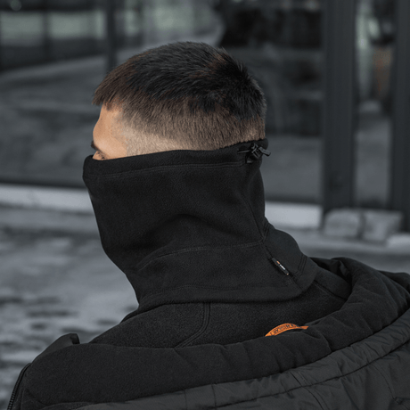 Mand med M-Tac Anatomisk Snood Justerbar Elite Fleece (320 g/m²) iført som halsvarmer, justering synlig bagpå, mod beskyttelse af elementer.