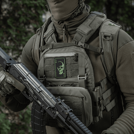 Person with M-Tac Patch Face of War (Embroidered) on vest, embroidered skull inspired by Vietnam cards, attached with Velcro, tactical gear.