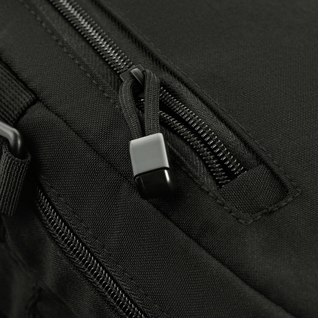 Close-up of zipper details on black M-Tac Assistant Bag with adjustable straps and MOLLE panels.