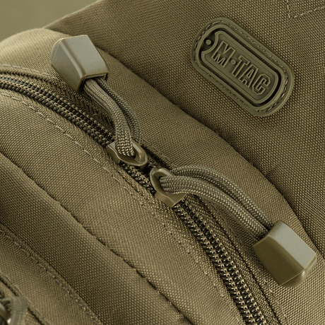 Close-up of zipper and logo on M-Tac Assistant Bag in leather-look with adjustable belt and MOLLE panels.