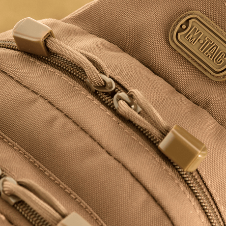 Close-up of M-Tac Assistant Bag with zippers and logo, single-shoulder backpack with MOLLE panels and adjustable strap for everyday use.