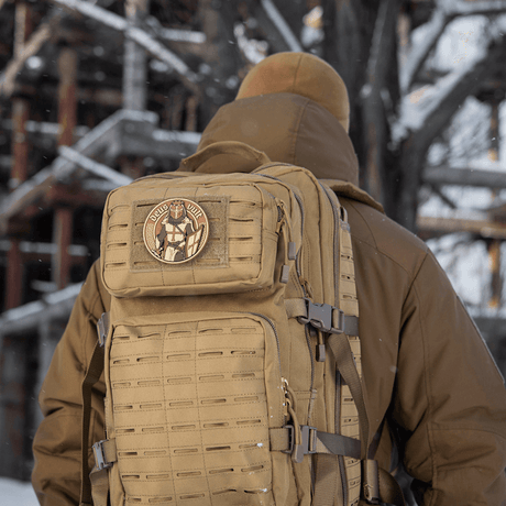 M-Tac Deus Vult 3D PVC Patch mounted on a tactical backpack in a winter landscape.