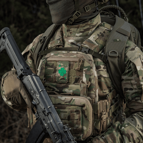 Military clothing with M-Tac Patch Lucky Card (Embroidered) with clover, attached with Velcro to camouflaged backpack.