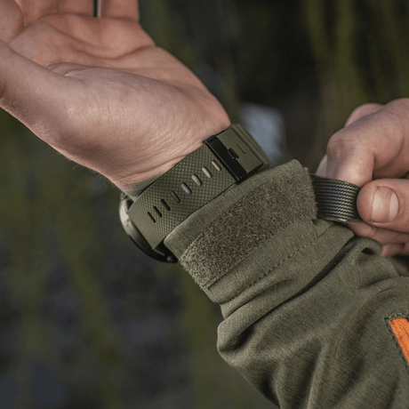 Person adjusting M‑Tac Multifunctional Tactical Watch, ideal for military use and outdoor activities, with robust case and advanced features