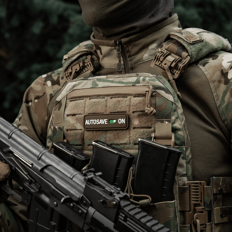 M-Tac Patch Autosave PVC attached to a tactical vest, 3D morale patch with Velcro and full coverage color, ideal for outdoor gear.