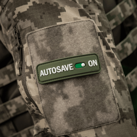 M-Tac Patch Autosave PVC on camouflage jacket, 3D effect, PVC material, Velcro backing, ideal for tactical gear.
