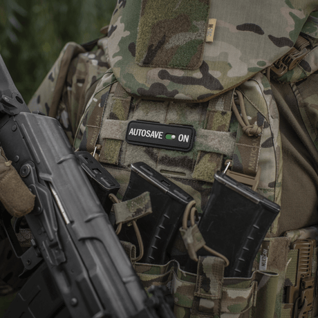 M-Tac Patch Autosave PVC on a camouflage jacket with magazine pouches, showing detailed 3D design and color clarity, ideal for tactical use.