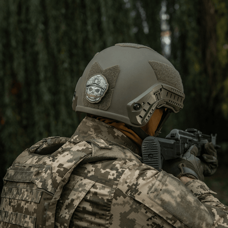 Soldier wearing a tactical helmet with M-Tac Patch Emoji #4 in the forest, PVC with 3D effect and Velcro, morale patch, 6.5 x 6.5 cm, durable and fun.