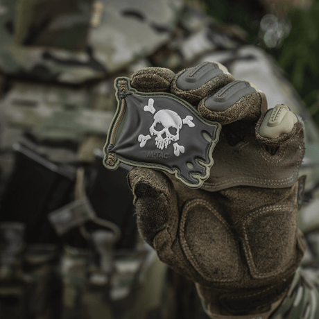 M-Tac Jolly Roger PVC in 3D design, held by a gloved hand, symbolizes adventurous spirit, with Velcro on the back, 8x5 cm.