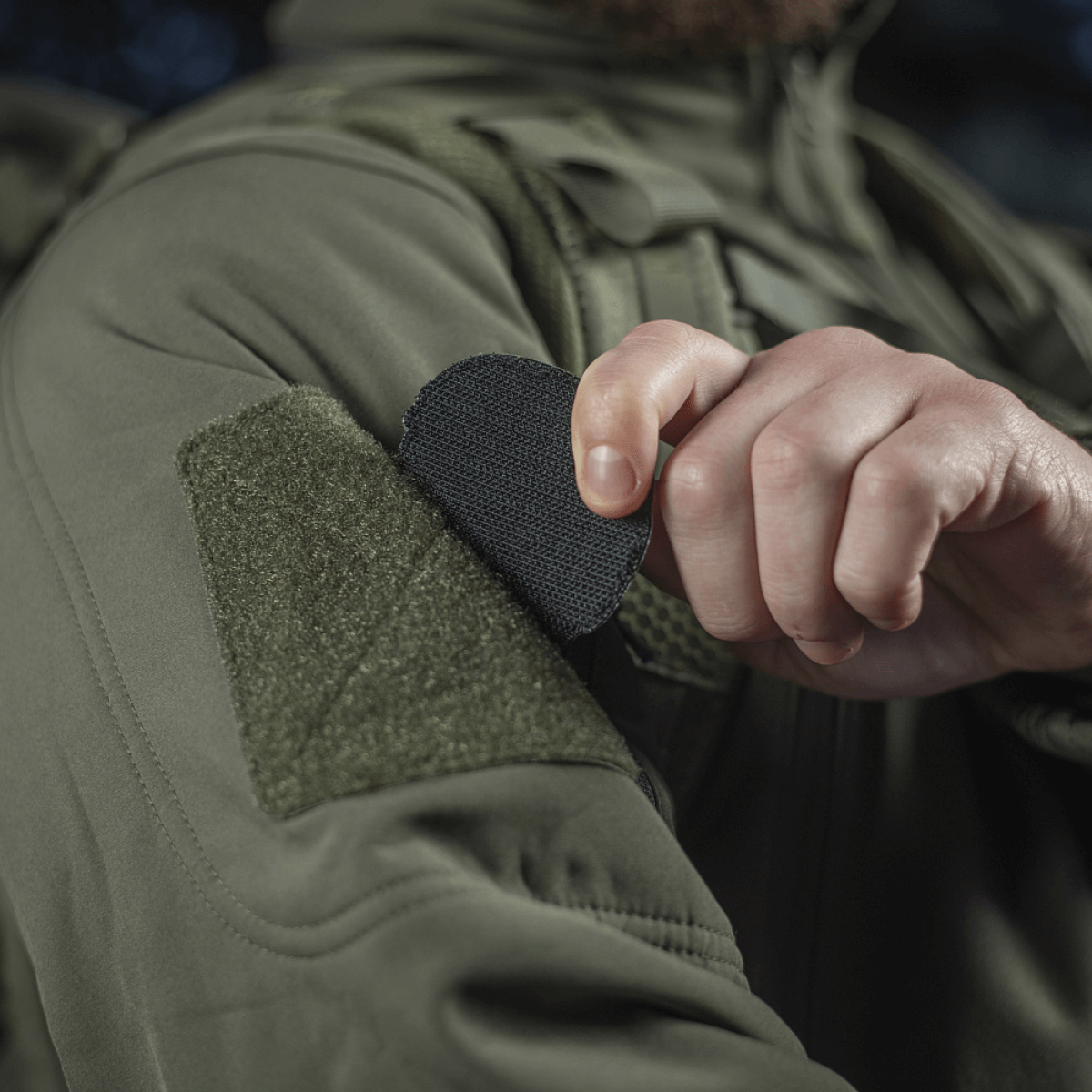 Person fastgør M-Tac Patch Operator 3D PVC med Velcro på jakke, taktisk design, morale patch, 6x7 cm, lavet af PVC.