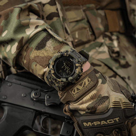M-Tac Tactical Watch 2037 on a camouflage-clad hand, showing rugged design with LED backlight and features for tactical use.